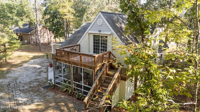 rear view of house with a sunroom and a wooden deck