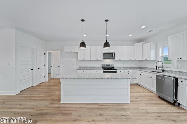 kitchen with a center island, pendant lighting, stainless steel appliances, and white cabinets