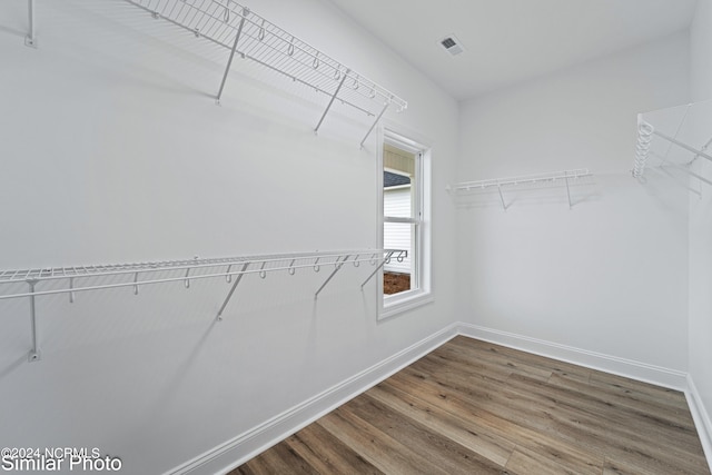 walk in closet with hardwood / wood-style flooring