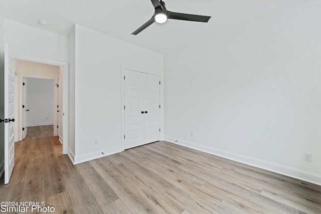 unfurnished bedroom featuring light wood-type flooring, ceiling fan, and a closet