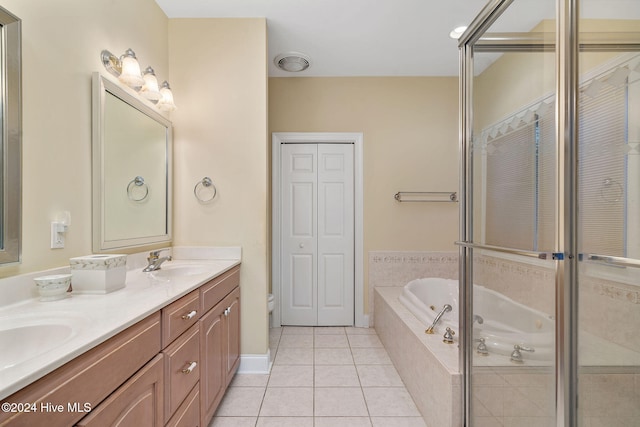 bathroom featuring tile patterned floors, tiled tub, vanity, and toilet