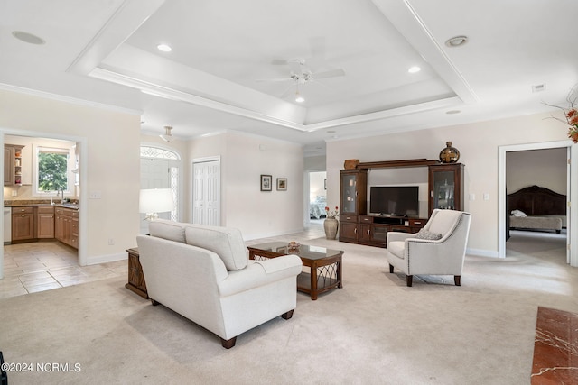 carpeted living room featuring a raised ceiling, ceiling fan, and crown molding