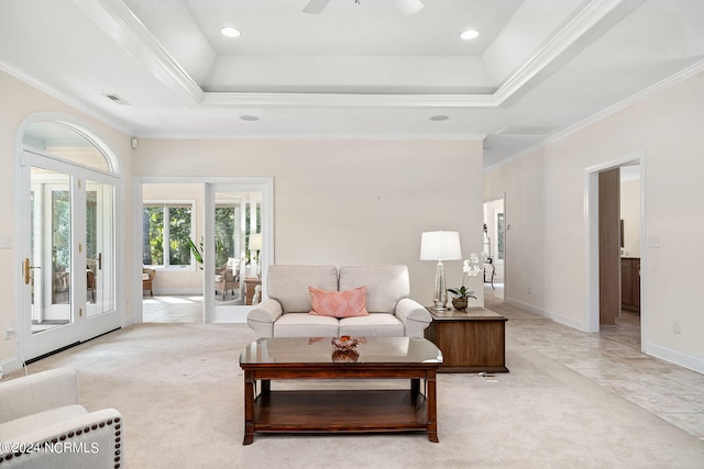 living room with ceiling fan, crown molding, a tray ceiling, and french doors