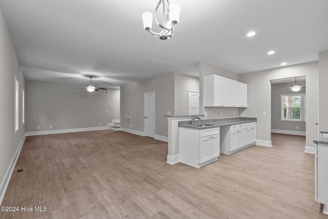 kitchen with white cabinetry, light hardwood / wood-style flooring, and pendant lighting