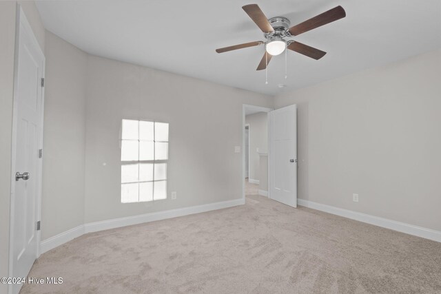 carpeted empty room featuring ceiling fan