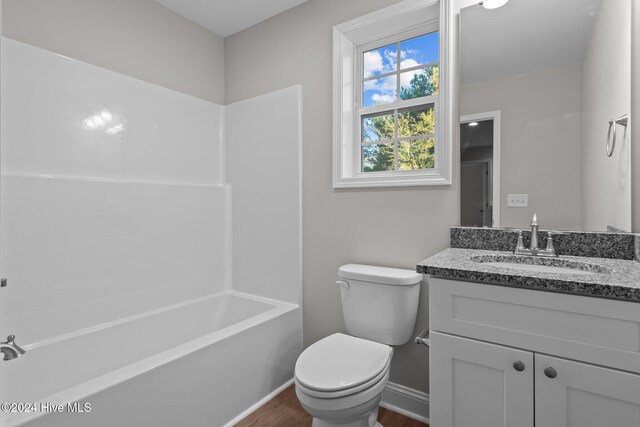 full bathroom with bathing tub / shower combination, toilet, vanity, and hardwood / wood-style flooring