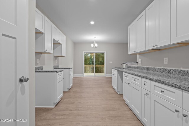 kitchen featuring light hardwood / wood-style flooring, white cabinets, sink, and stone counters