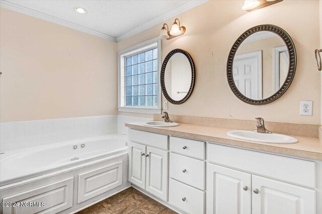 bathroom featuring a bathing tub, tile patterned floors, a textured ceiling, vanity, and ornamental molding