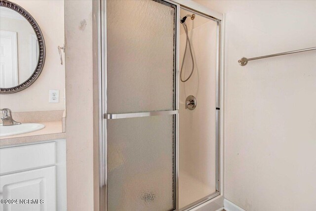 bathroom with vanity and a shower with shower door