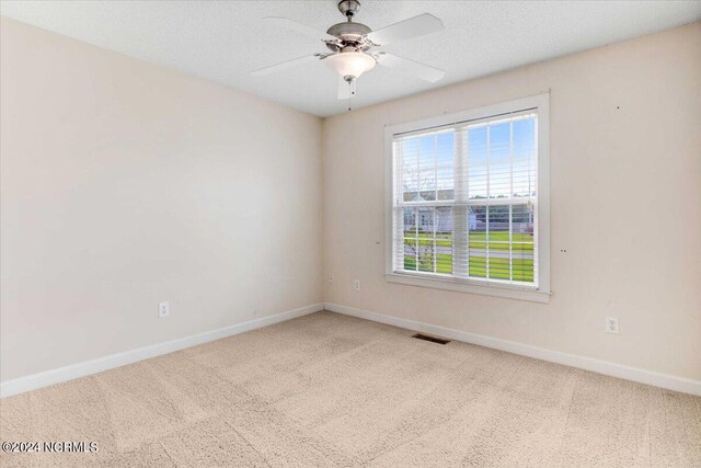 unfurnished room featuring ceiling fan, carpet floors, and a textured ceiling