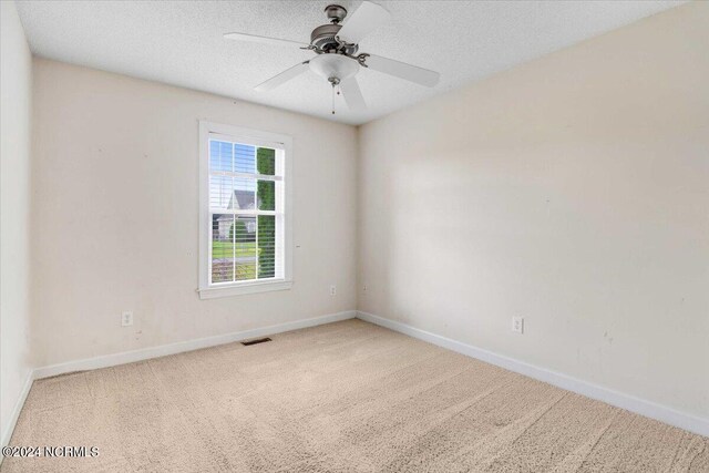 carpeted empty room with a textured ceiling and ceiling fan