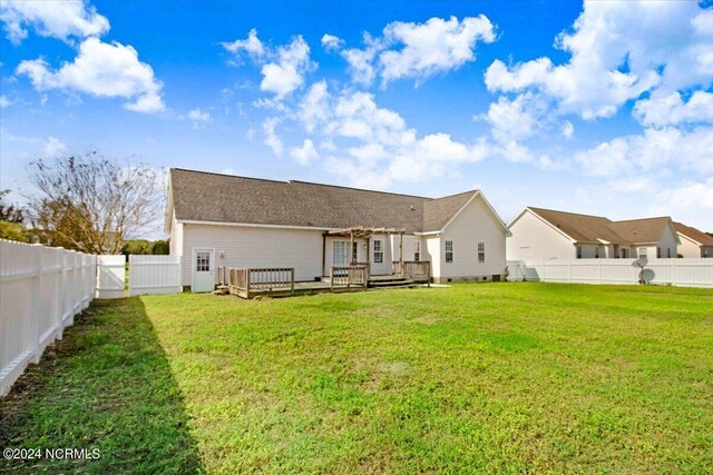 rear view of property with a lawn and a deck