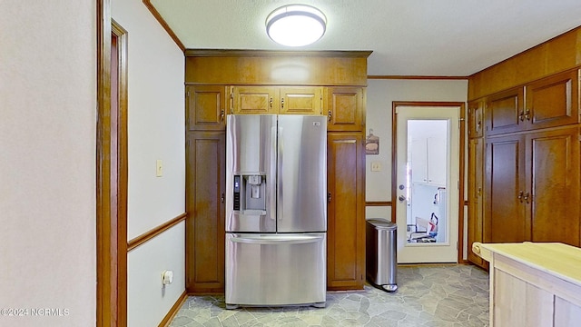 kitchen featuring ornamental molding, stainless steel fridge, and a textured ceiling