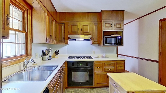 kitchen with built in microwave, stainless steel gas stovetop, black oven, and sink