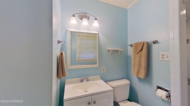 bathroom with vanity, crown molding, and toilet