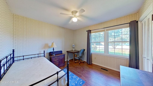 bedroom with hardwood / wood-style flooring, a closet, and ceiling fan