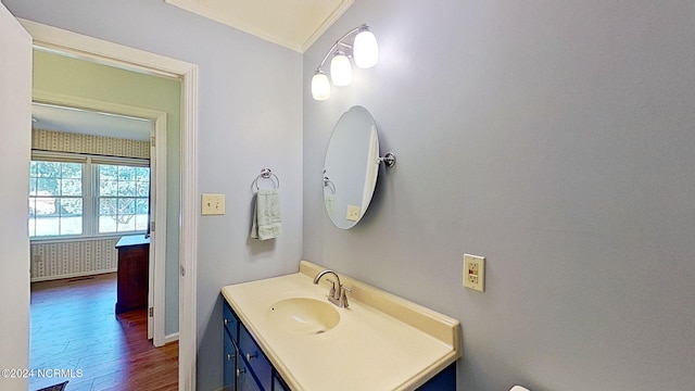 bathroom with vanity, ornamental molding, and hardwood / wood-style floors