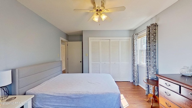 bedroom with a closet, ceiling fan, and light wood-type flooring