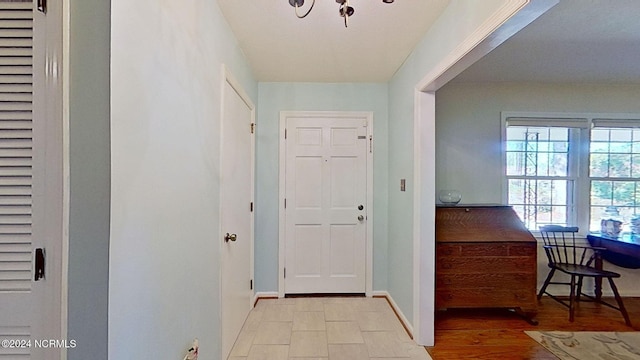 doorway featuring a chandelier and light hardwood / wood-style floors