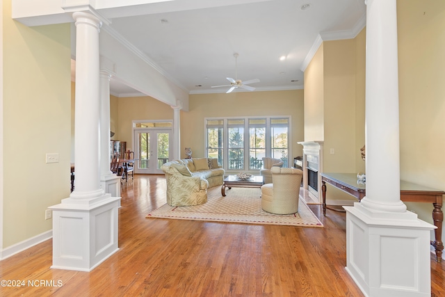 living room with ornamental molding, light wood-type flooring, and ceiling fan