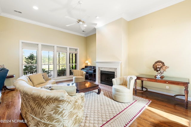 living room featuring a premium fireplace, crown molding, hardwood / wood-style flooring, and ceiling fan