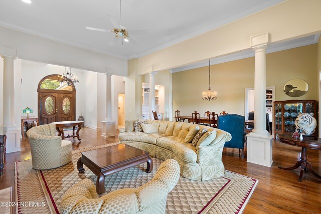 living room featuring hardwood / wood-style floors, ornate columns, crown molding, and ceiling fan with notable chandelier