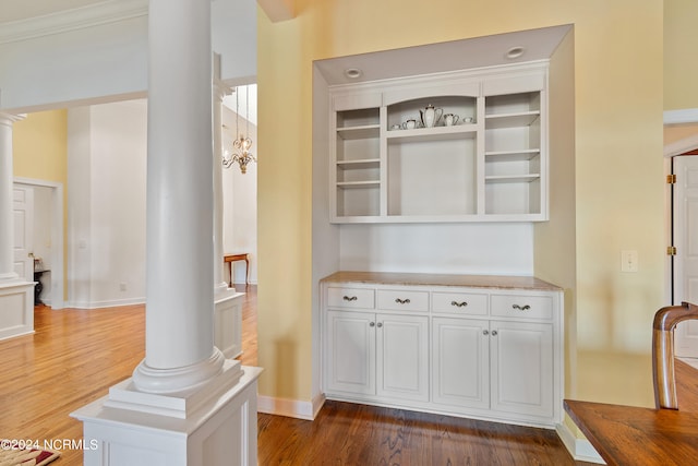 room details featuring ornamental molding, hardwood / wood-style flooring, and ornate columns