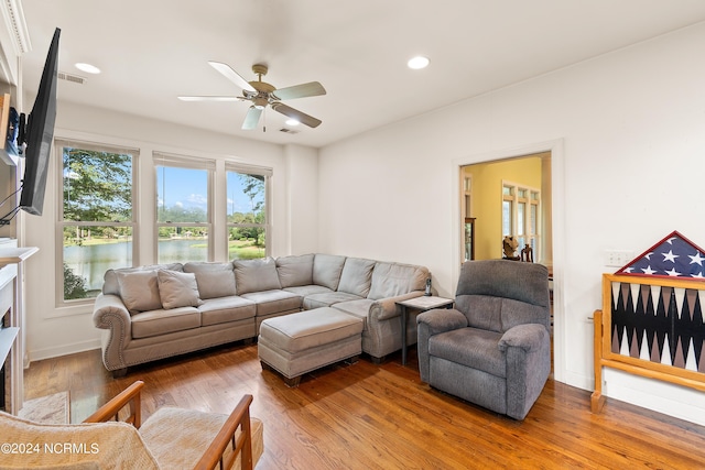 living room featuring a water view, ceiling fan, and hardwood / wood-style flooring