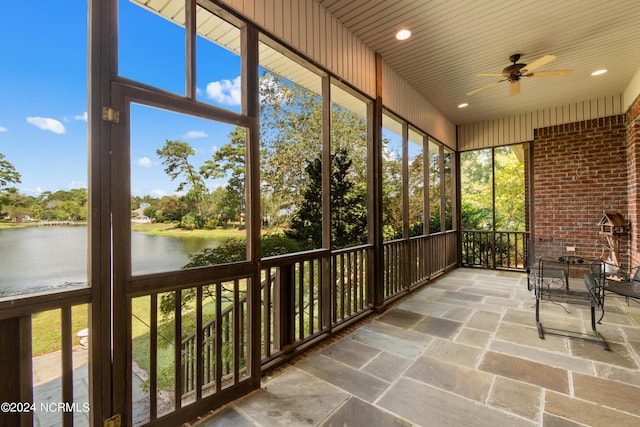 unfurnished sunroom featuring a water view, ceiling fan, and wooden ceiling