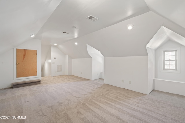 additional living space with vaulted ceiling and light colored carpet