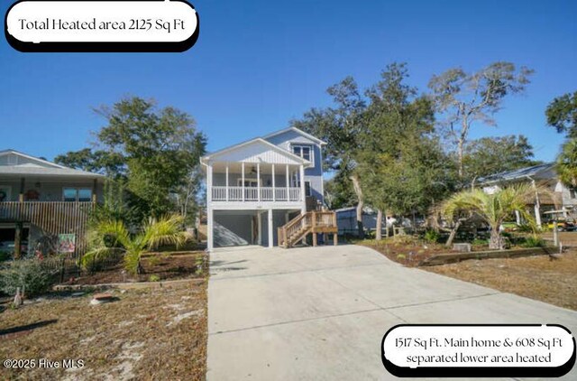 coastal home with covered porch, ceiling fan, and a garage