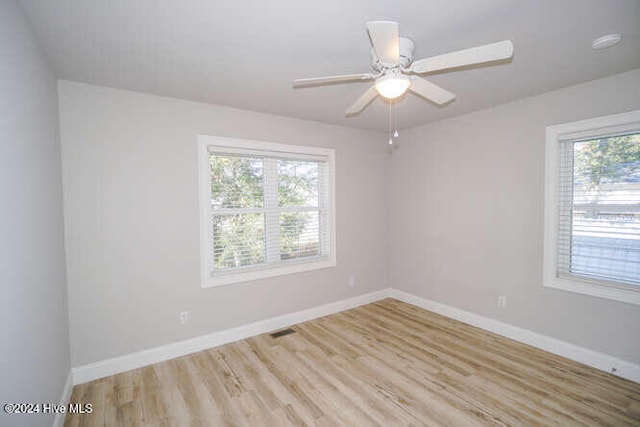 unfurnished room featuring light wood-style flooring, visible vents, baseboards, and ceiling fan