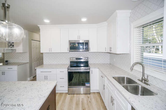 kitchen featuring stainless steel appliances, a sink, and white cabinetry