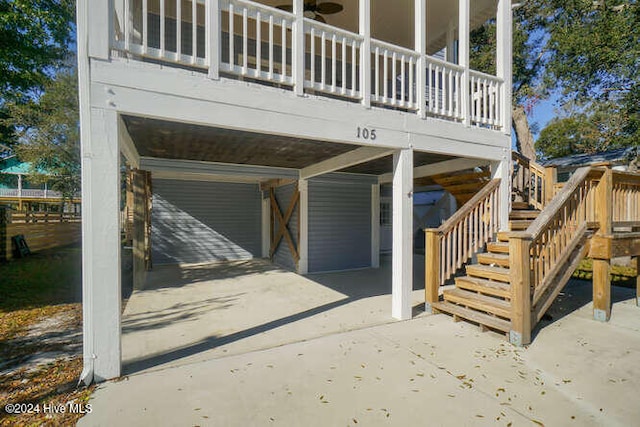 view of property exterior featuring a carport, a patio, and stairs