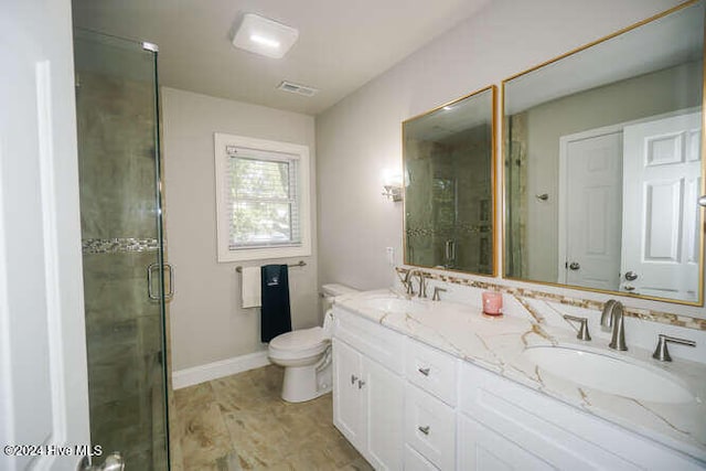 bathroom with a shower with door, vanity, and toilet