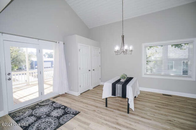 entryway featuring high vaulted ceiling, wood finished floors, baseboards, and an inviting chandelier