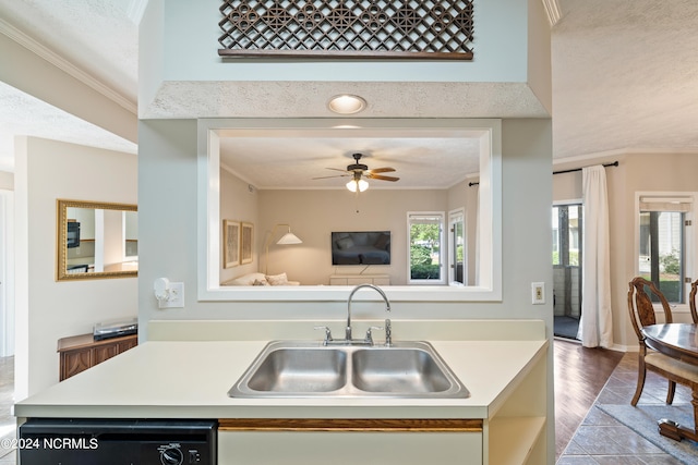 kitchen featuring dishwasher, light countertops, a sink, and crown molding