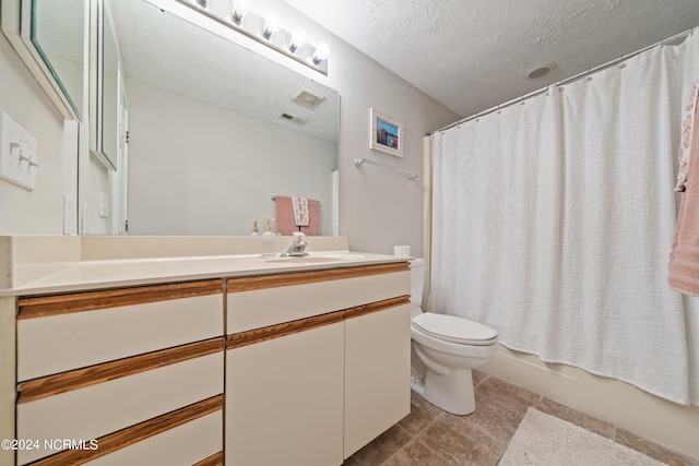 full bathroom with vanity, shower / bath combination with curtain, a textured ceiling, toilet, and tile patterned floors