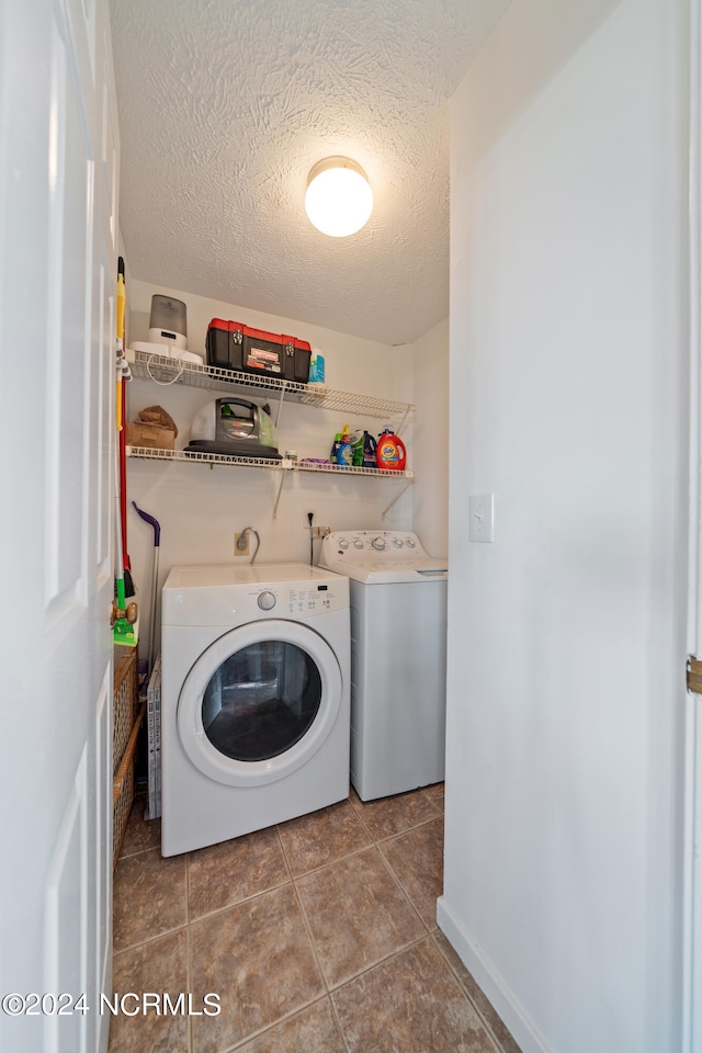 laundry room featuring tile patterned flooring, a textured ceiling, and independent washer and dryer