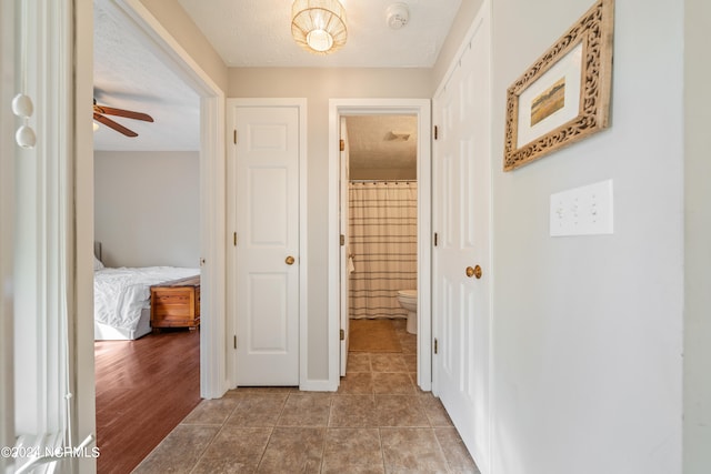 hall with wood-type flooring and a textured ceiling