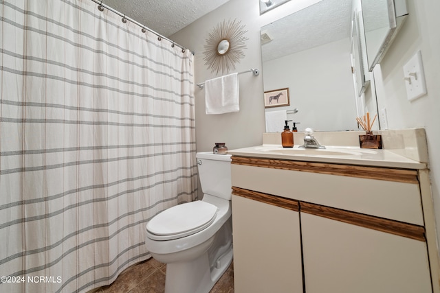 bathroom with toilet, tile patterned floors, a textured ceiling, and vanity