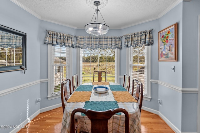 dining room with light hardwood / wood-style flooring, a chandelier, a textured ceiling, and crown molding