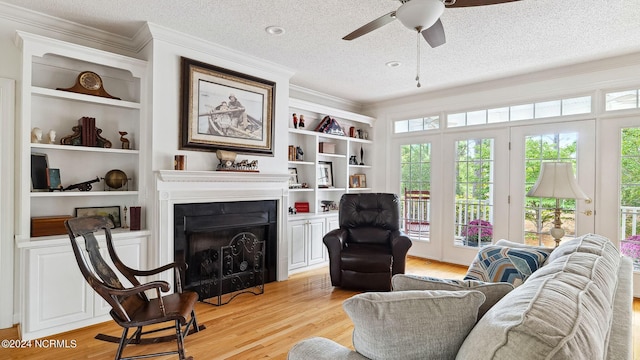 living room featuring ceiling fan, a textured ceiling, crown molding, and light hardwood / wood-style floors