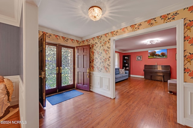 foyer entrance with french doors, light hardwood / wood-style flooring, and crown molding