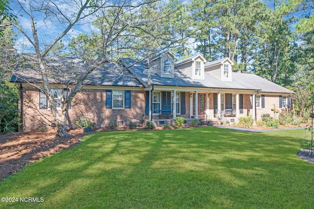 new england style home with a front yard and covered porch