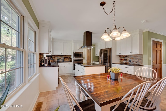 tiled dining space with ornamental molding and a chandelier