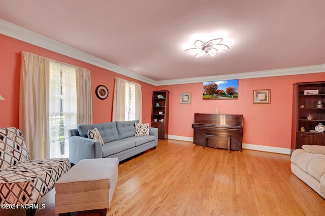 living room with ornamental molding, light wood-type flooring, and built in features