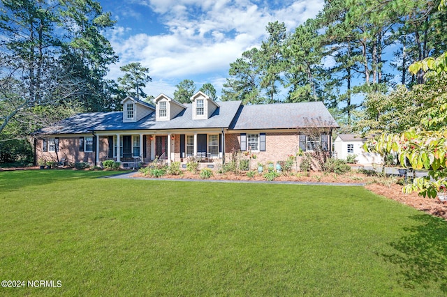 new england style home featuring a front lawn and covered porch