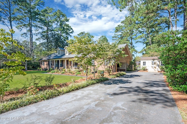 cape cod house featuring a front yard