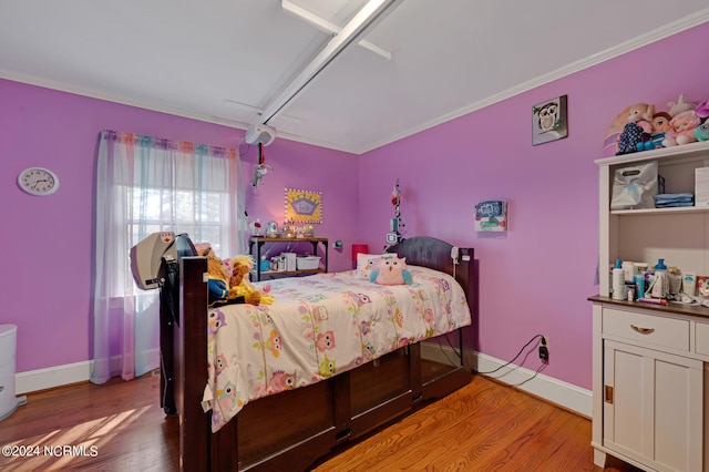 bedroom with light wood-type flooring and crown molding